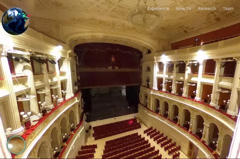 interior view of Galli Theatre with decorative ceiling, side stalls and red seats looking down on stage