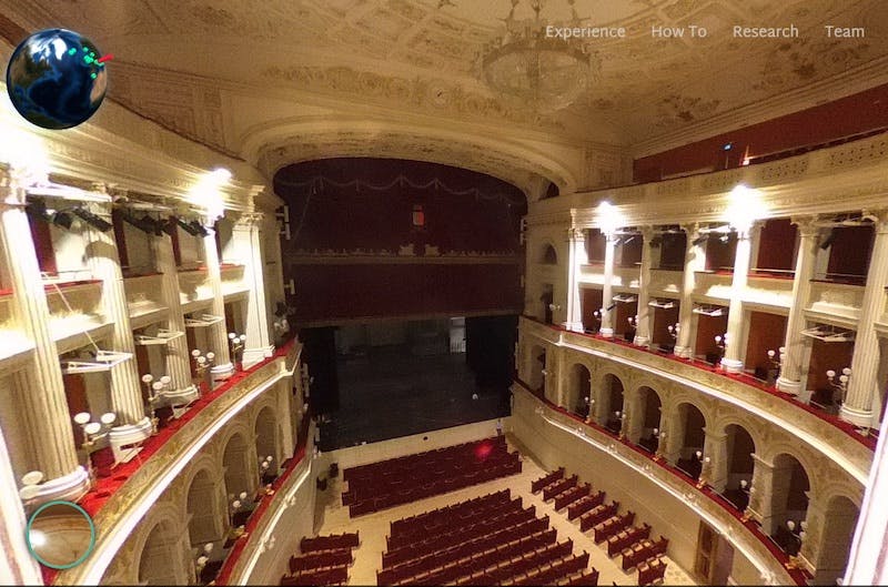 interior view of Galli Theatre with decorative ceiling, side stalls and red seats looking down on stage