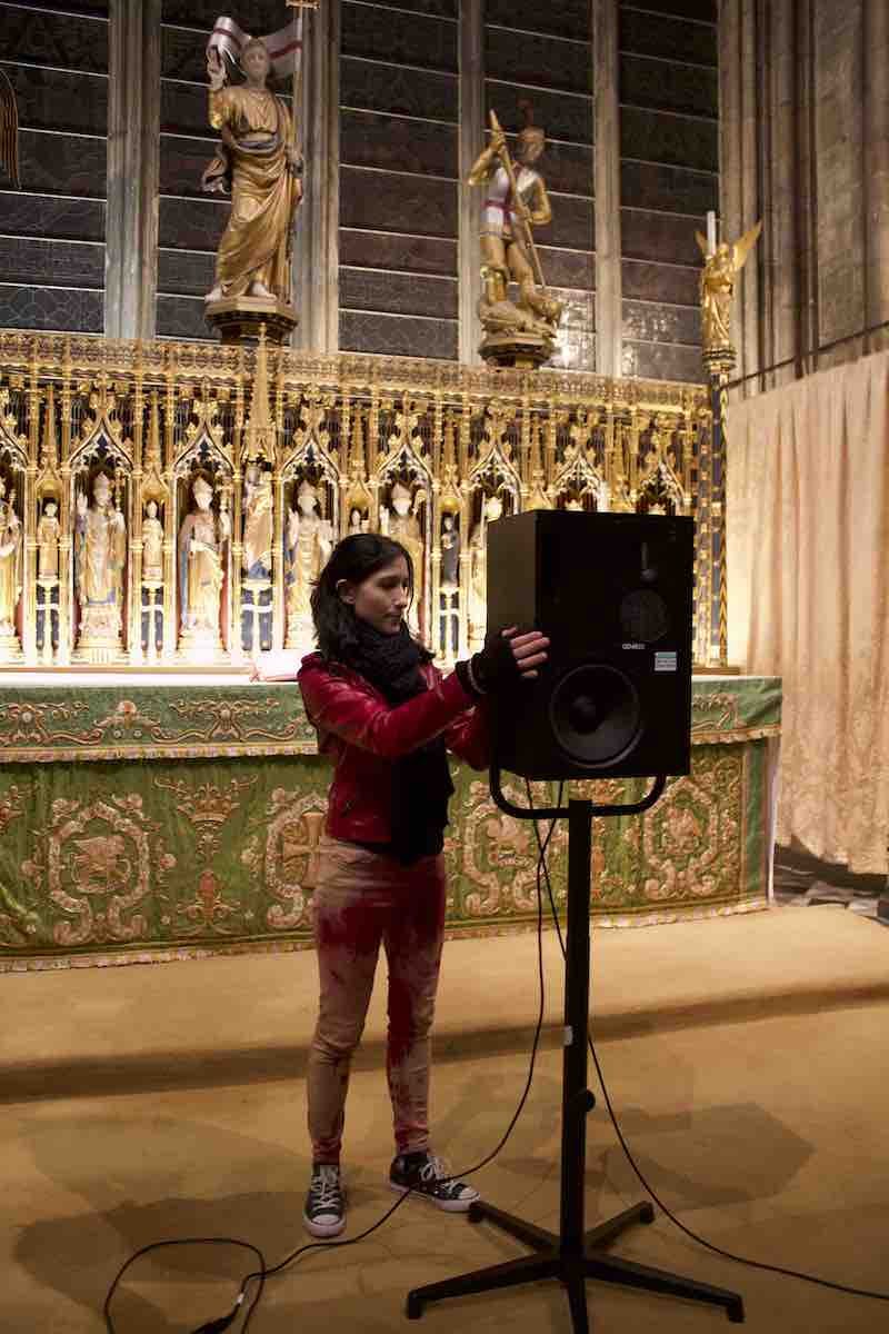 Mariana adjusting a loudspeaker in a church.